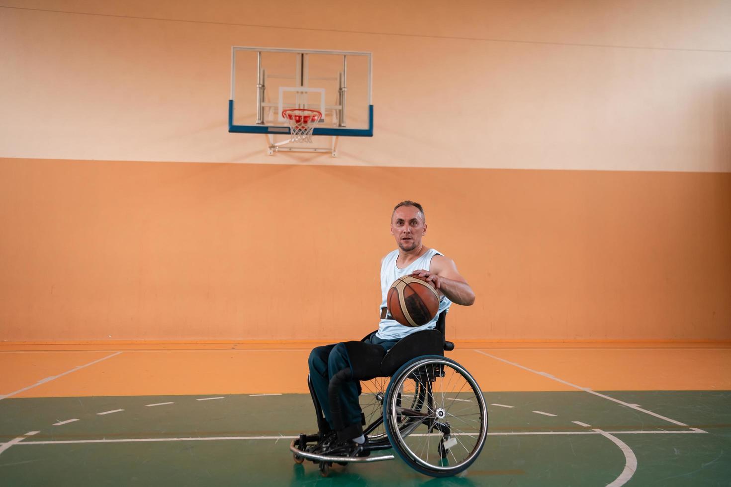 ein Foto eines Kriegsveteranen, der in einer modernen Sportarena Basketball spielt. das Konzept des Sports für Menschen mit Behinderungen