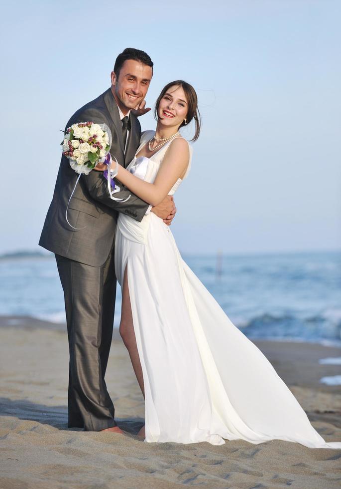 romantische Strandhochzeit bei Sonnenuntergang foto