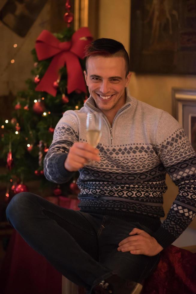 glücklicher junger Mann mit einem Glas Champagner foto