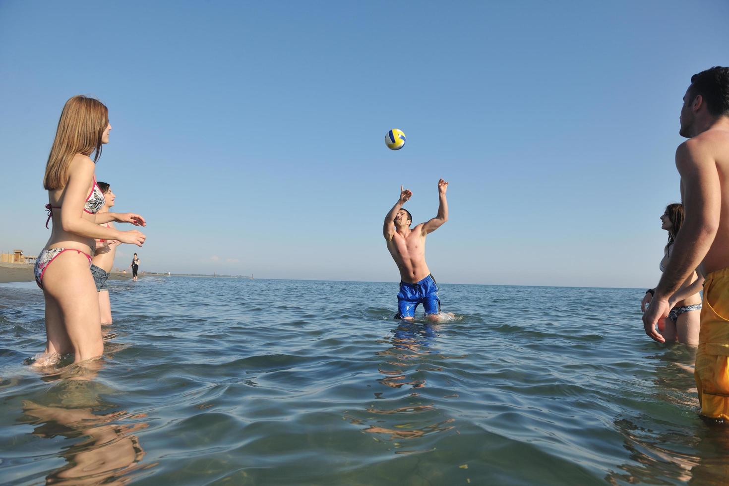 Jugendgruppe Spaß haben und Beachvolleyball spielen foto