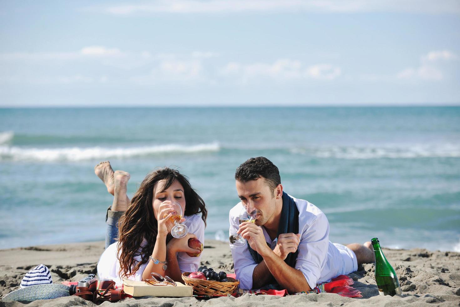 junges Paar beim Picknick am Strand foto