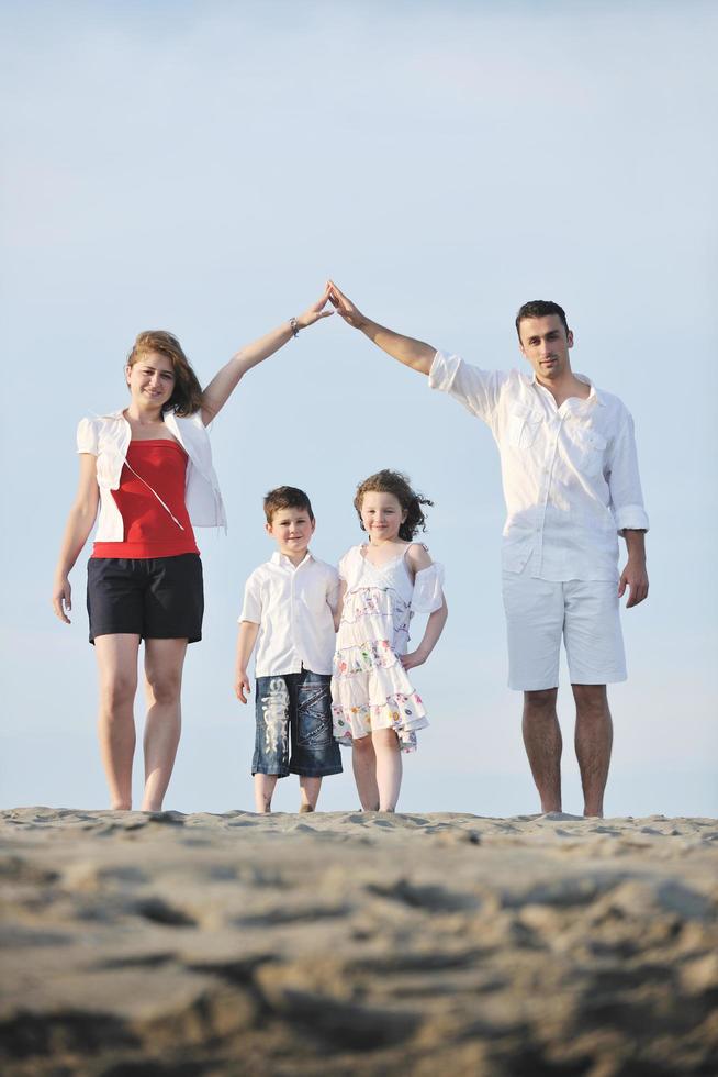 Familie am Strand mit Heimzeichen foto