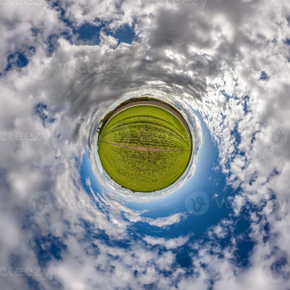 winziger Planet am blauen Himmel mit schönen Wolken mit Transformation des sphärischen Panoramas 360 Grad. sphärische abstrakte Luftaufnahme. Krümmung des Raumes. foto