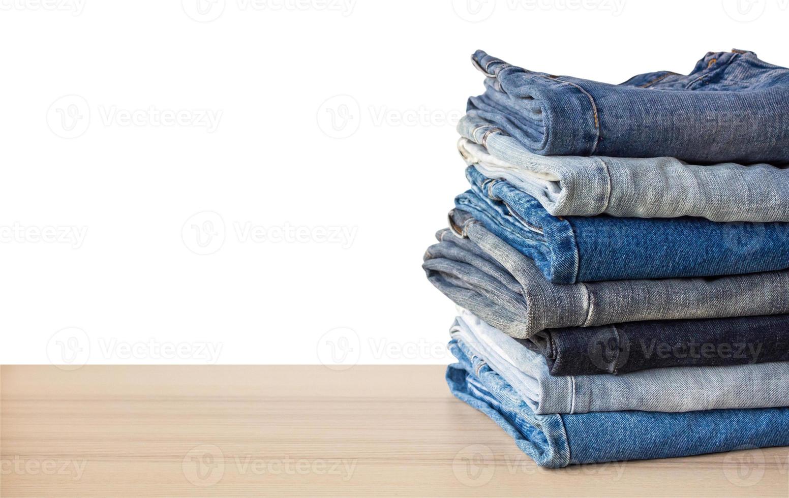 Denim-Blue-Jeans-Stack auf Holztisch isoliert auf weißem Hintergrund foto