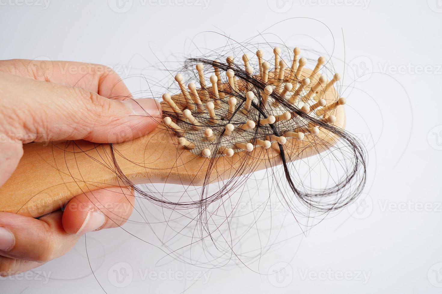 asiatische Frau hat Probleme mit langem Haarausfall an der Kammbürste. foto