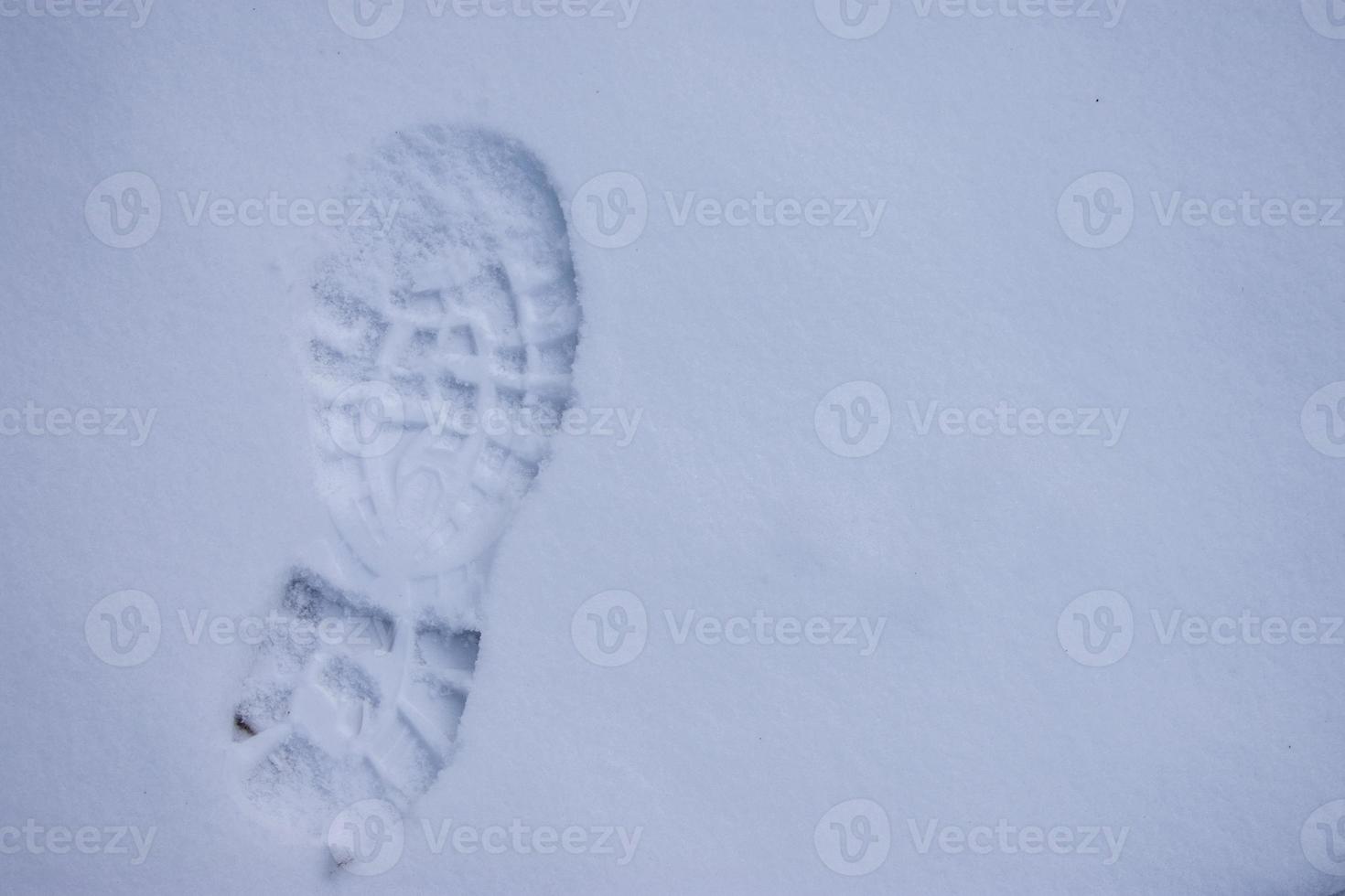 Fußabdruck eines Wanderschuhs auf dem jungfräulichen Schnee foto
