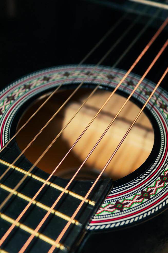 die Saiten einer klassischen schwarzen Gitarre foto