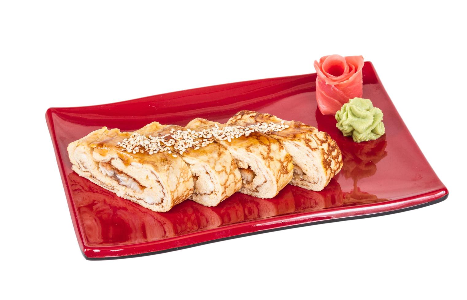 Omelett-Maki-Sushi - Rolle aus geräuchertem Aal im Inneren. belegt mit japanischem Omelett und Soße foto