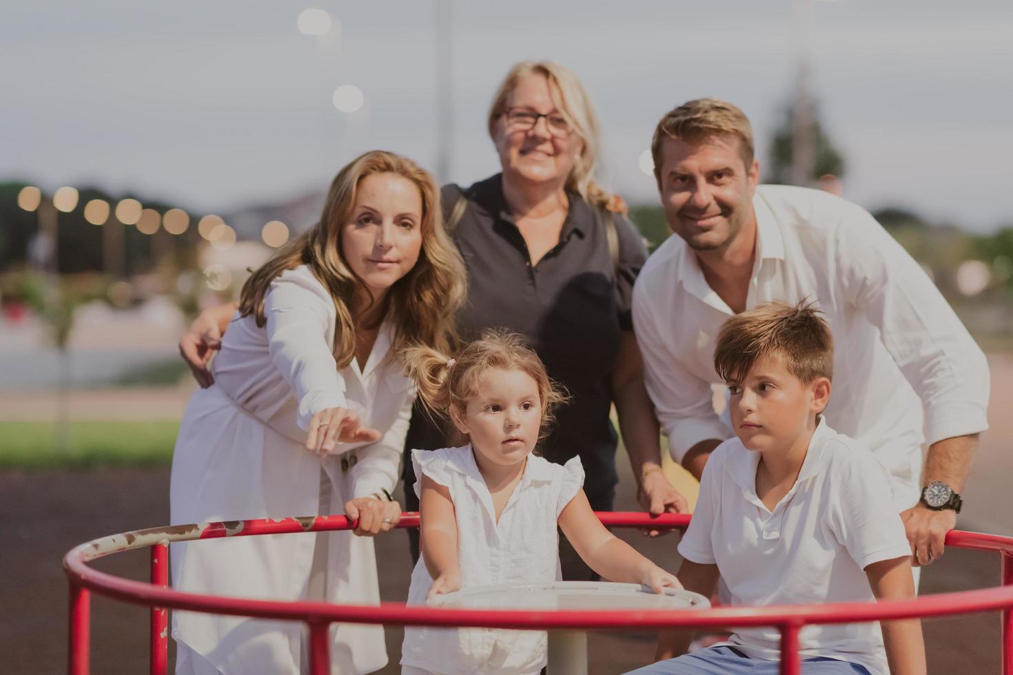 ein älteres ehepaar in legerer kleidung verbringt mit seinen kindern und der großmutter zeit zusammen im park im urlaub. Familienzeit. selektiver Fokus foto