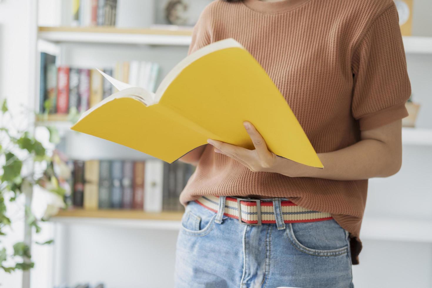 Nahaufnahme der Frau, die ein gelbes Buch liest foto