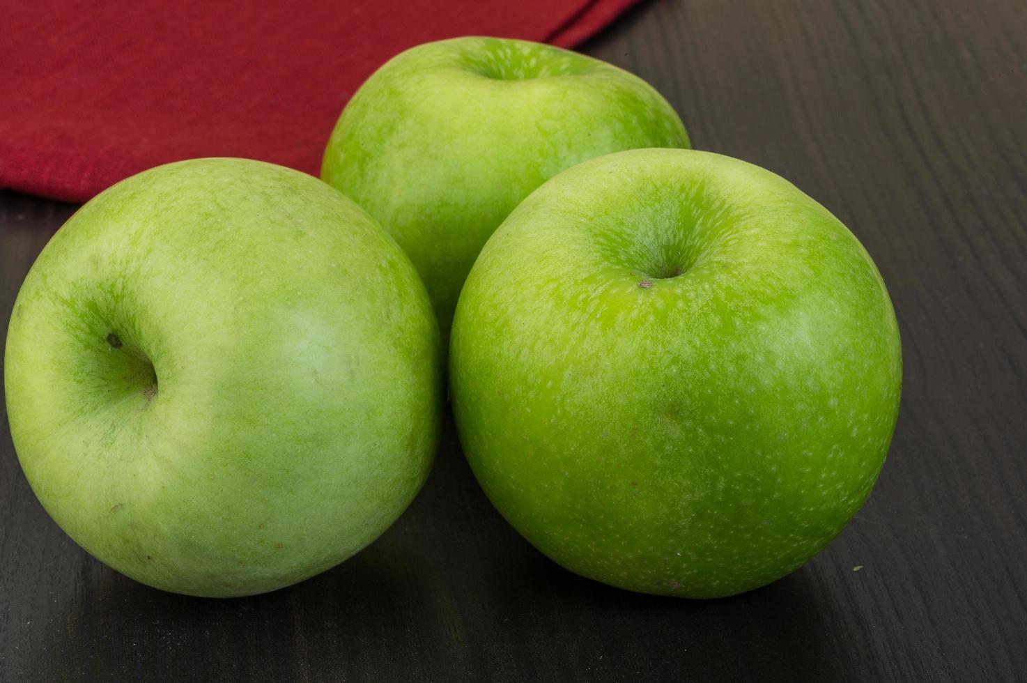 grüner Apfel auf hölzernem Hintergrund foto