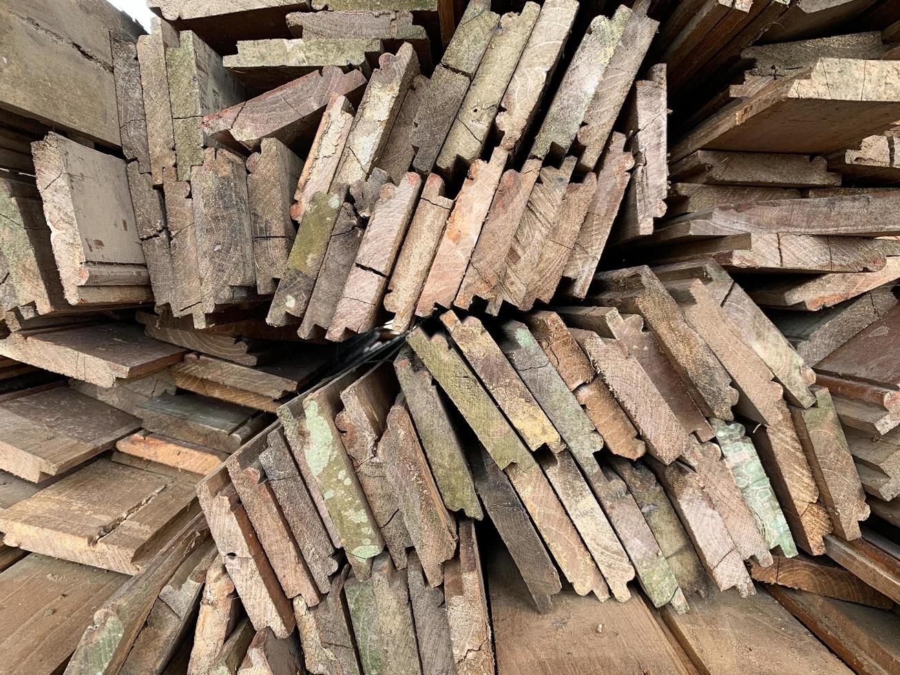 Unregelmäßig gestapelter abstrakter Hintergrund aus Holz, alte Holzbretter, die sich auf den Bau des Hauses vorbereiten, Muster am Rand mehrerer Holzstücke. Handyfoto foto