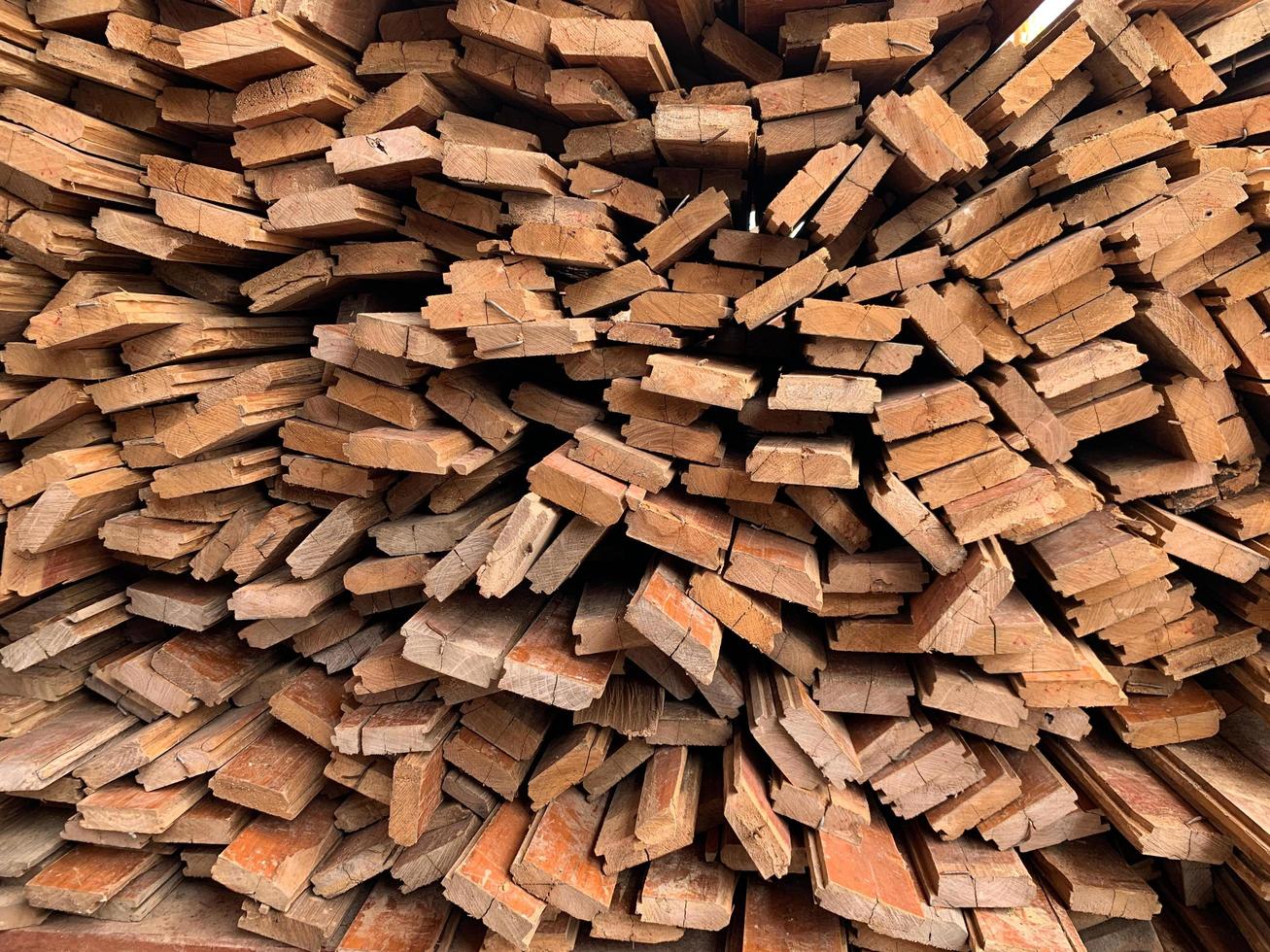 Unregelmäßig gestapelter abstrakter Hintergrund aus Holz, alte Holzbretter, die sich auf den Bau des Hauses vorbereiten, Muster am Rand mehrerer Holzstücke. Handyfoto foto