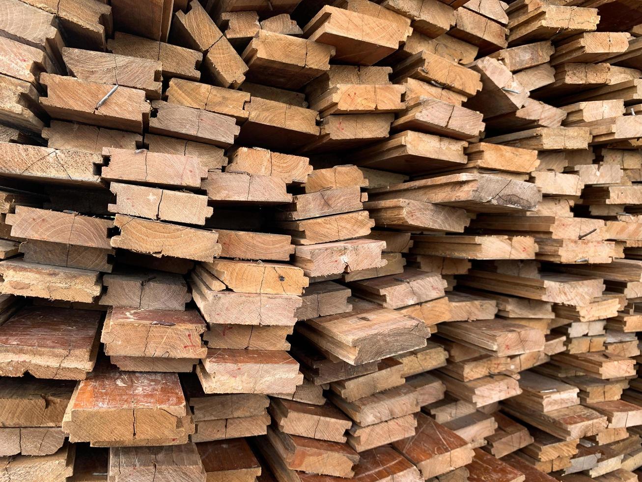 Unregelmäßig gestapelter abstrakter Hintergrund aus Holz, alte Holzbretter, die sich auf den Bau des Hauses vorbereiten, Muster am Rand mehrerer Holzstücke. Handyfoto foto