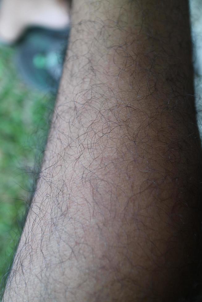 Die Hautstruktur der Füße eines Mannes ist braun und voller Fell foto