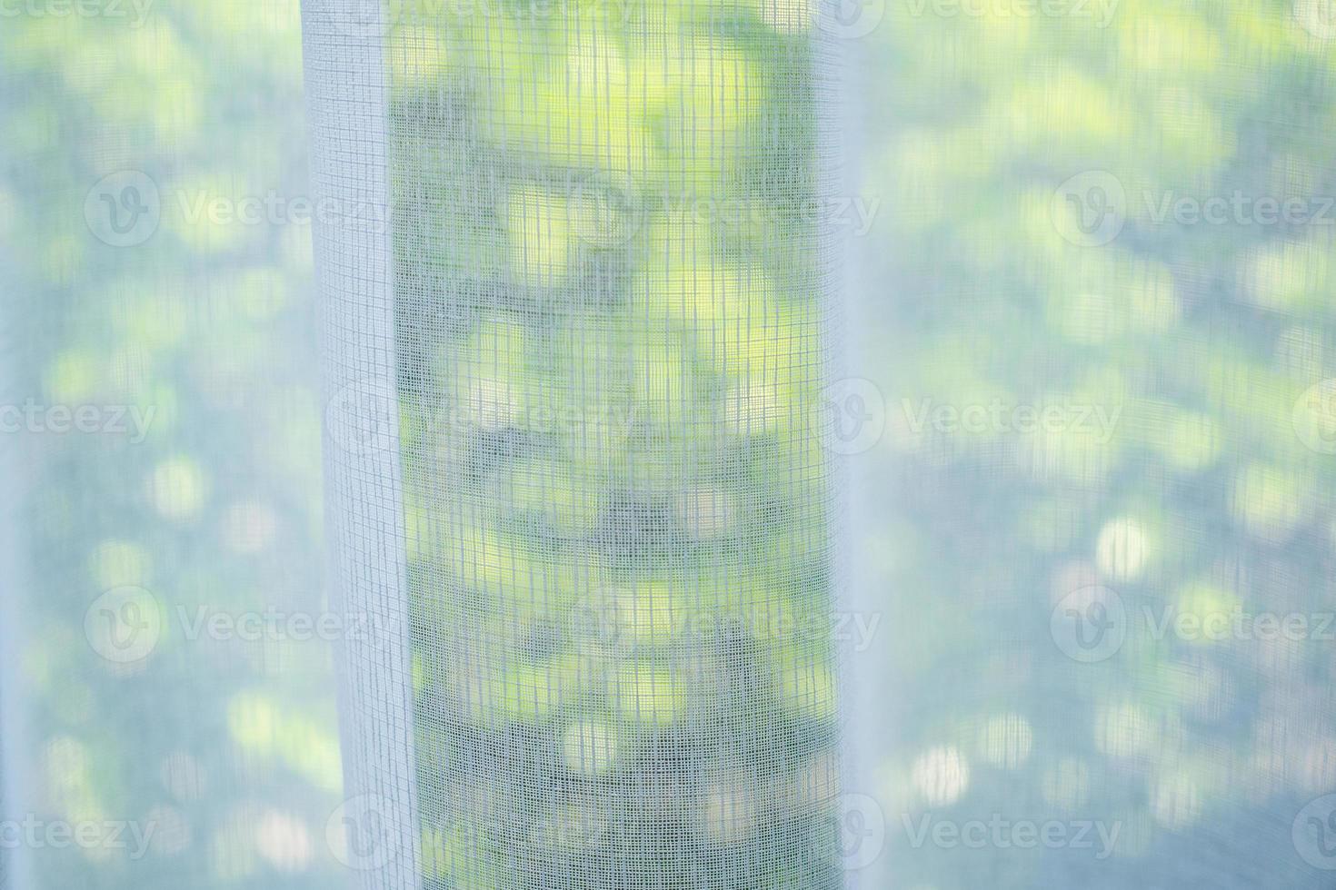 Vorhangfenster mit grünem Gartenhintergrund schließen foto