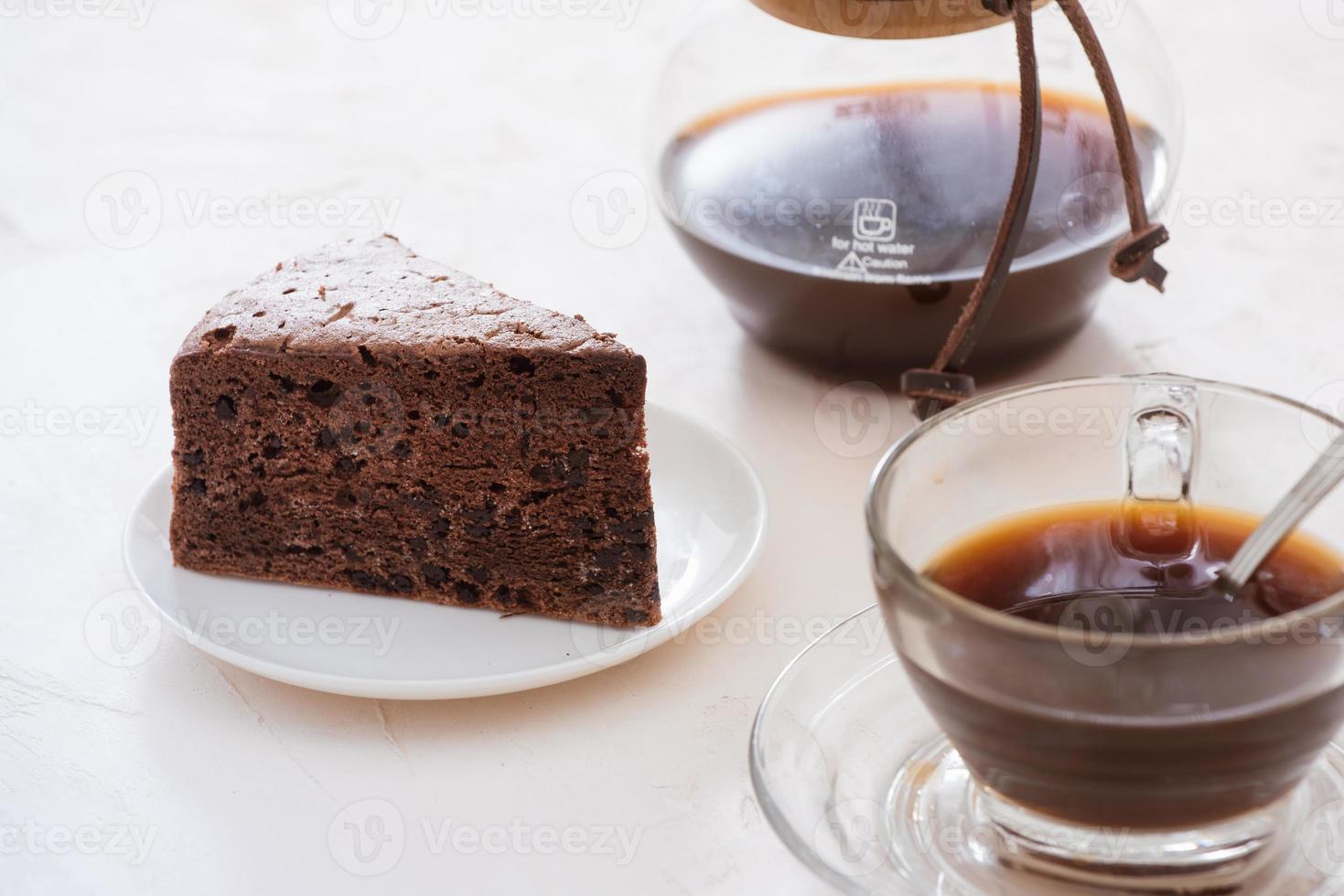 tropfkaffeetropfer und gemahlener kaffee mit glastropfkanne, tasse und schokoladenkuchen foto
