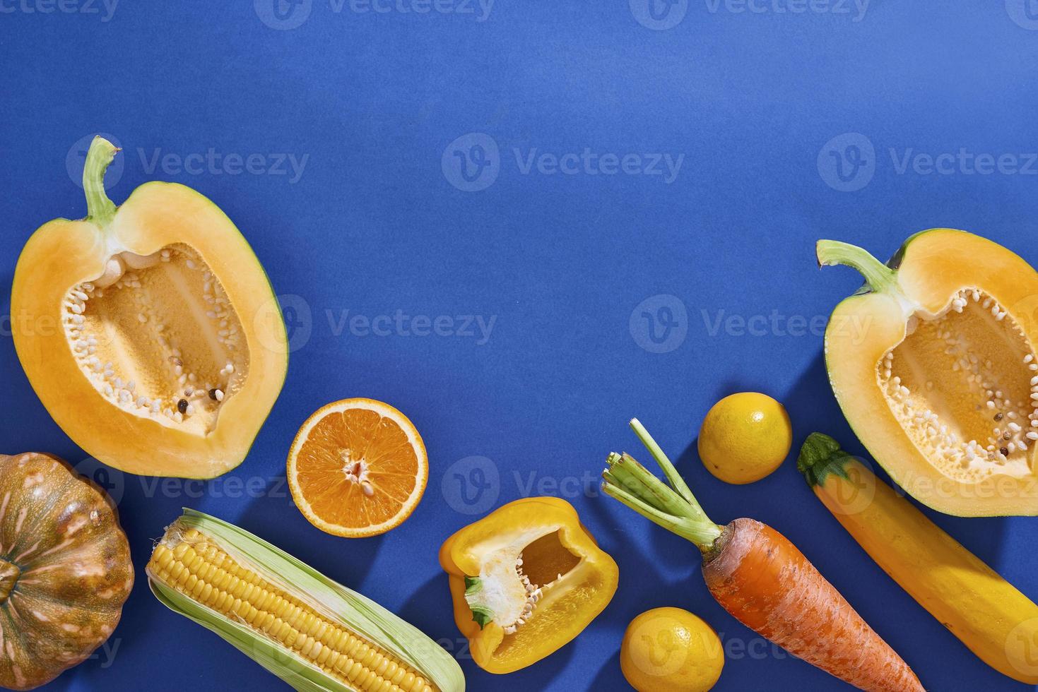 sammlung von frischem gelbem obst und gemüse auf blauem hintergrund foto