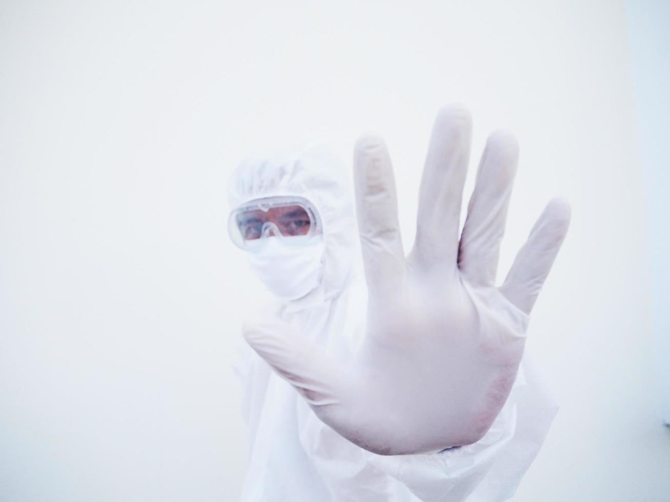 asiatischer männlicher arzt oder wissenschaftler in psa-uniform, der stoppschild zeigt, während er nach vorne schaut. coronavirus oder covid-19 konzept isolierter weißer hintergrund foto