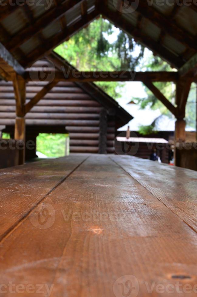 Innenraum einer Holzlaube, handgefertigt aus dunklem Holz im Wald foto