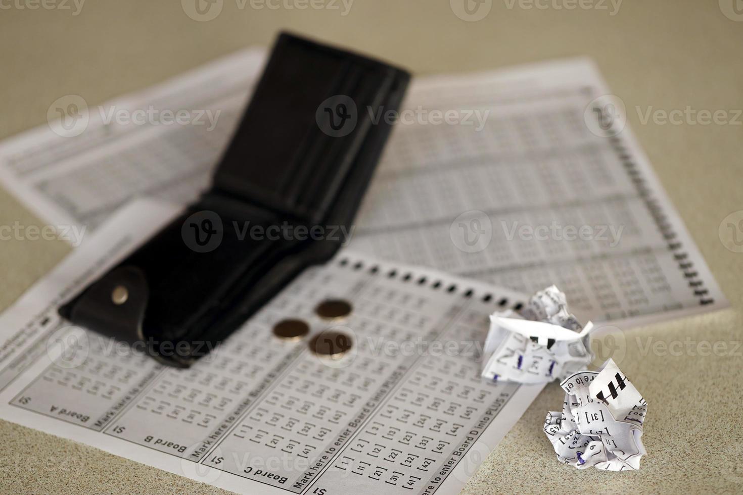 Zerknitterte Lottoscheine und leere Geldbörse als Symbol für das Verlieren des Lotteriespiels. unglückliche Spielergebnisse. Unglück foto
