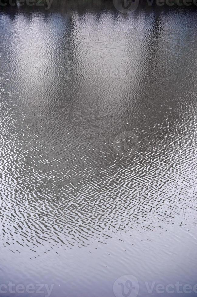 die Textur des Wassers im Fluss unter dem Einfluss des Windes. viele flache Wellen an der Wasseroberfläche foto