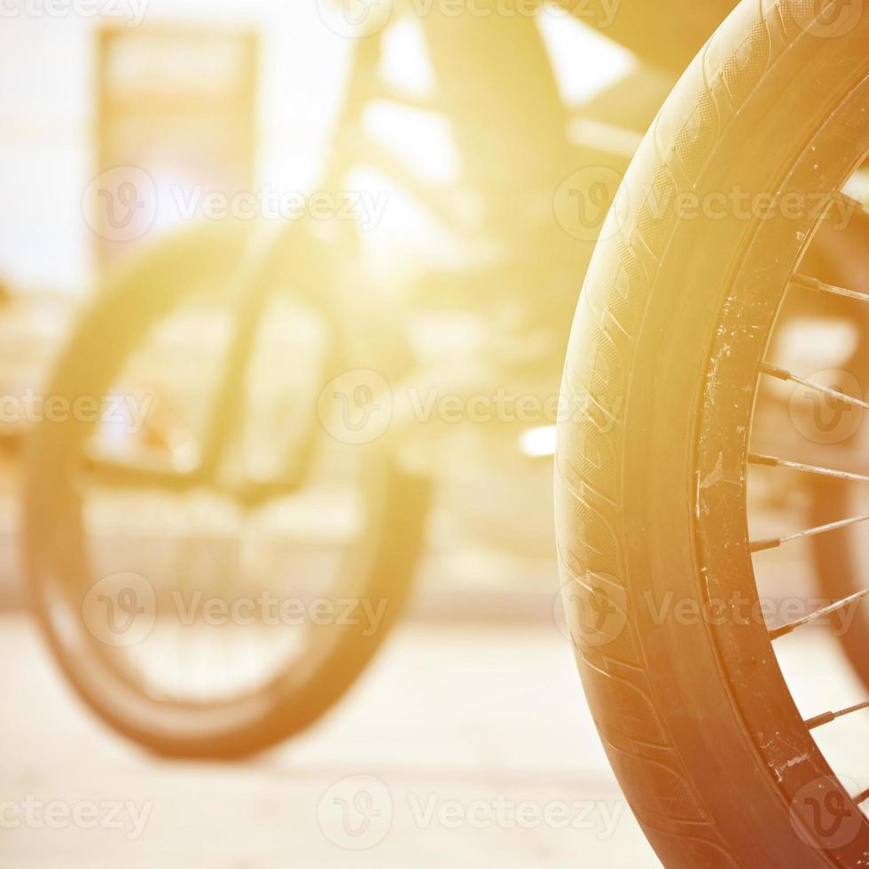 ein bmx-fahrradrad vor dem hintergrund einer unscharfen straße mit radfahrern. Extremsportkonzept foto