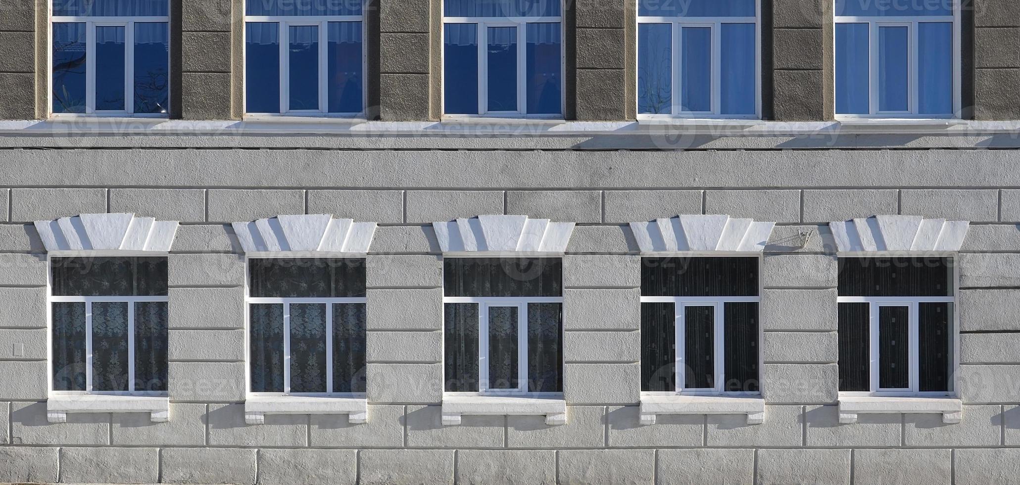 Textur eines verglasten modernen Fensters eines grauen Betongebäudes foto