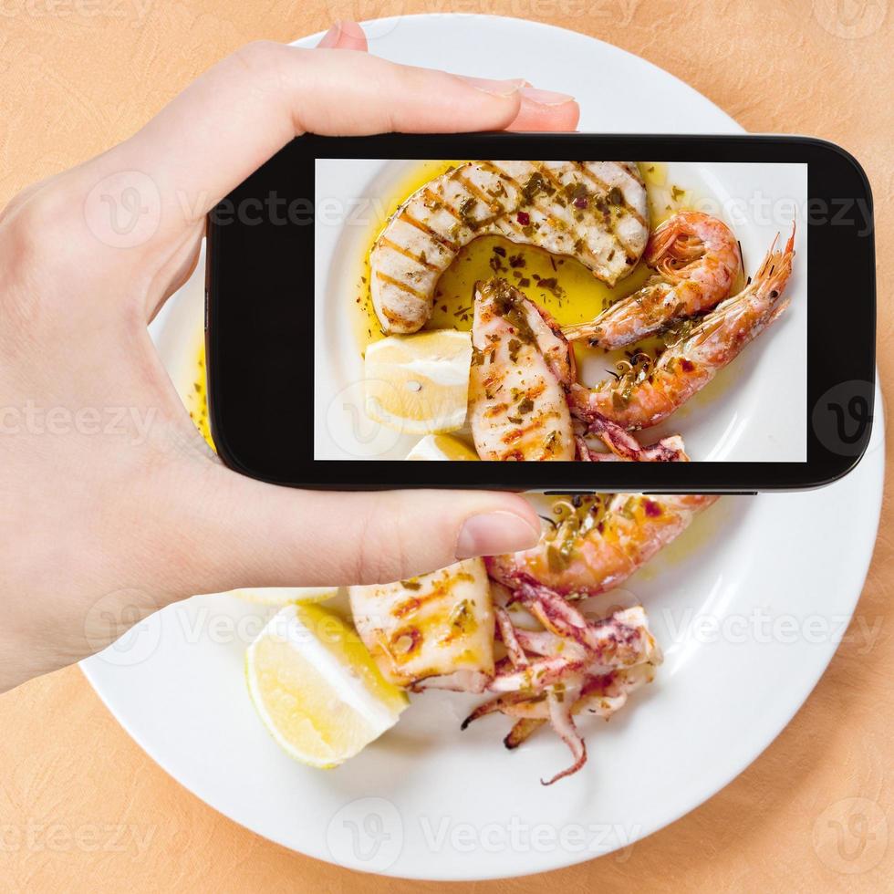 Tourist, der Foto von sizilianischer gegrillter Fischmischung macht