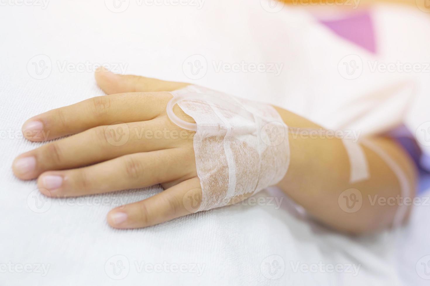 Nahaufnahme Menschen konzentrieren sich auf die Hand eines kranken Patienten auf dem Bett in der Krankenstation. Gesundheitswesen und Medizin. Linie Kochsalzlösung und Pulsdetektor Blutsauerstoffmessgerät am Finger der Menschen. foto