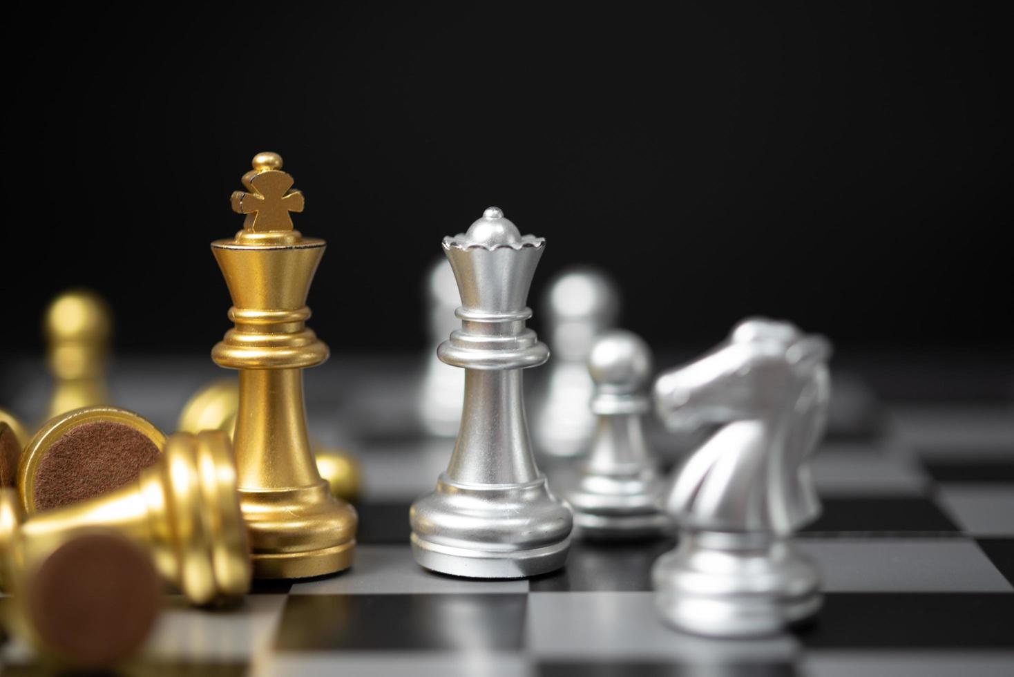Strategie- und Geschäftsplanungsideen. Der goldene Schachkönig steht der silbernen Königin auf dem Brett gegenüber. foto