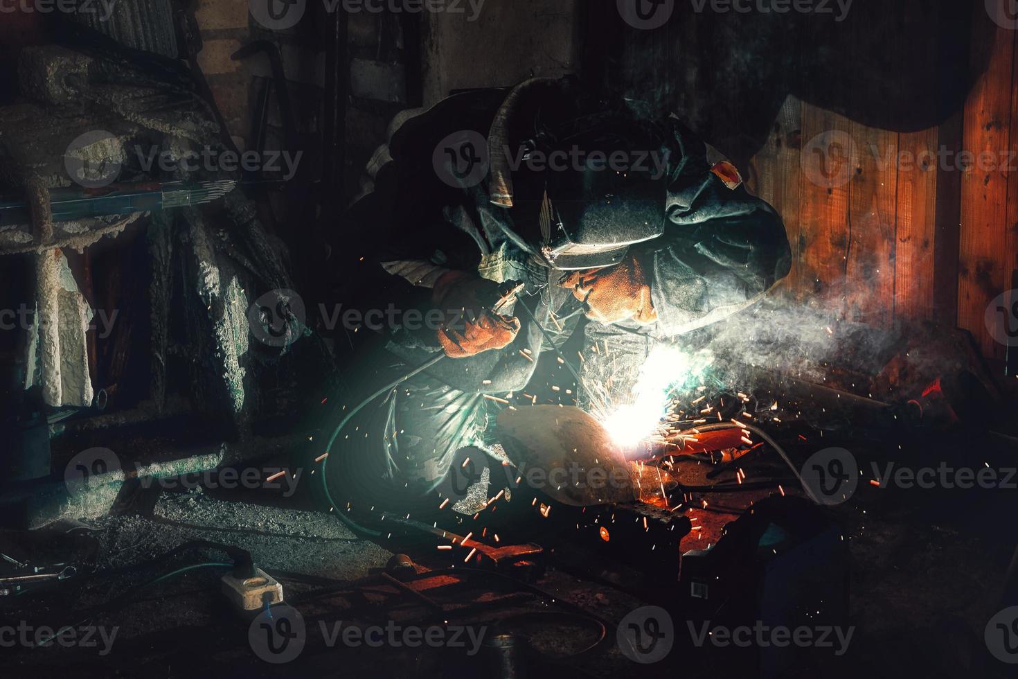 Arbeiterschweißer, der eine Nahtstoßverbindung an einem Rohr herstellt foto