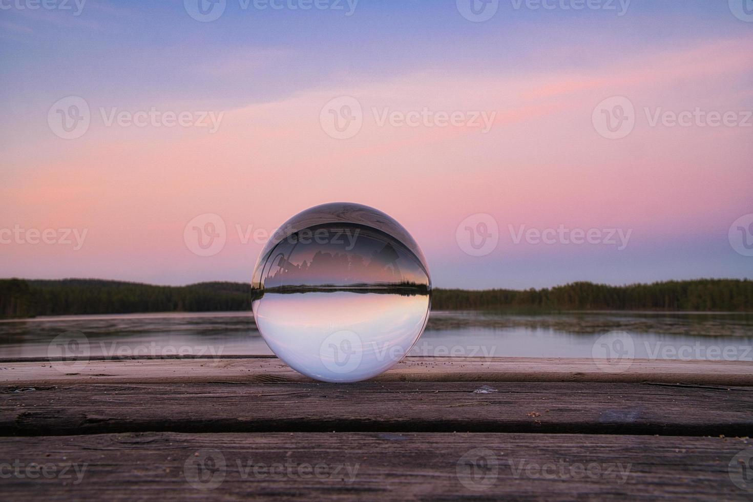 Glaskugel auf einem Holzsteg an einem schwedischen See zur Abendstunde. Natur Skandinavien foto