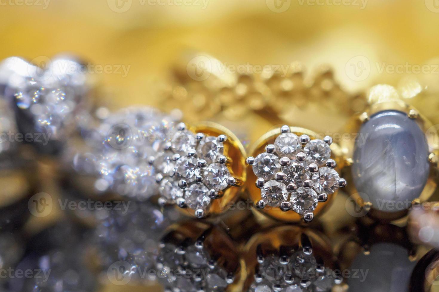 Luxus-Goldschmuck-Diamantohrringe und goldener Saphirring mit Reflektion auf schwarzem Hintergrund foto