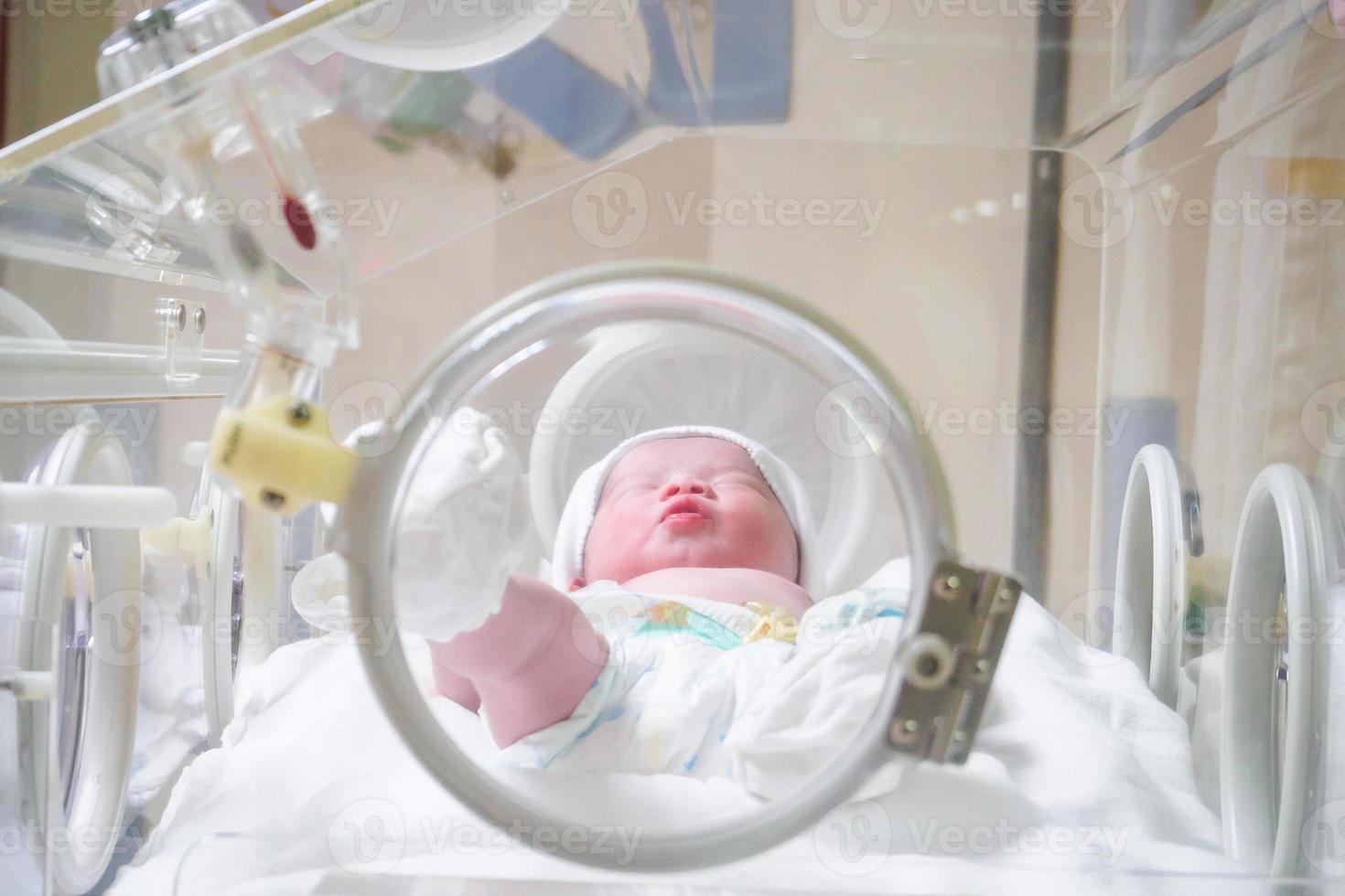 neugeborenes Mädchen im Inkubator im Kreißsaal des Krankenhauses foto