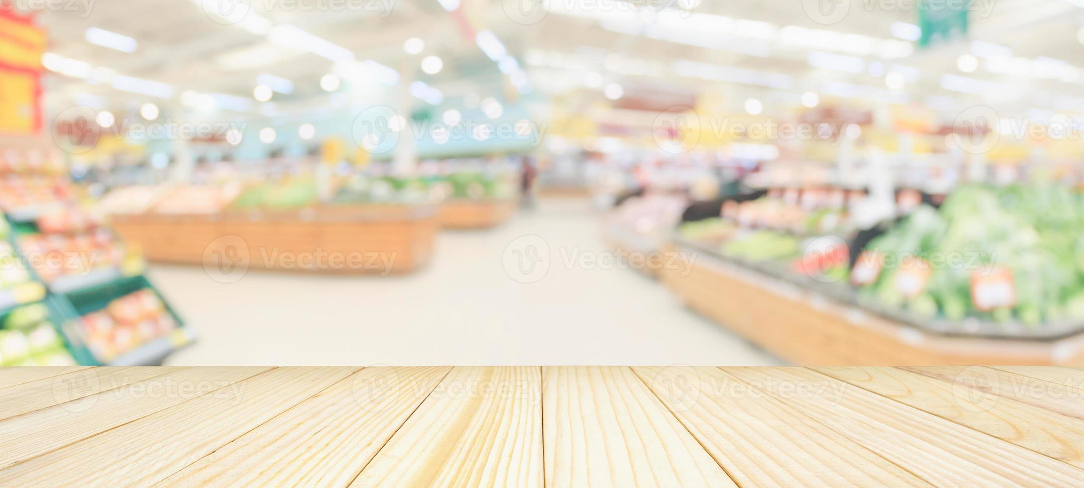 Holztischplatte mit Supermarkt-Lebensmittelgeschäft verschwommener, defokussierter Hintergrund mit Bokeh-Licht für die Produktpräsentation foto