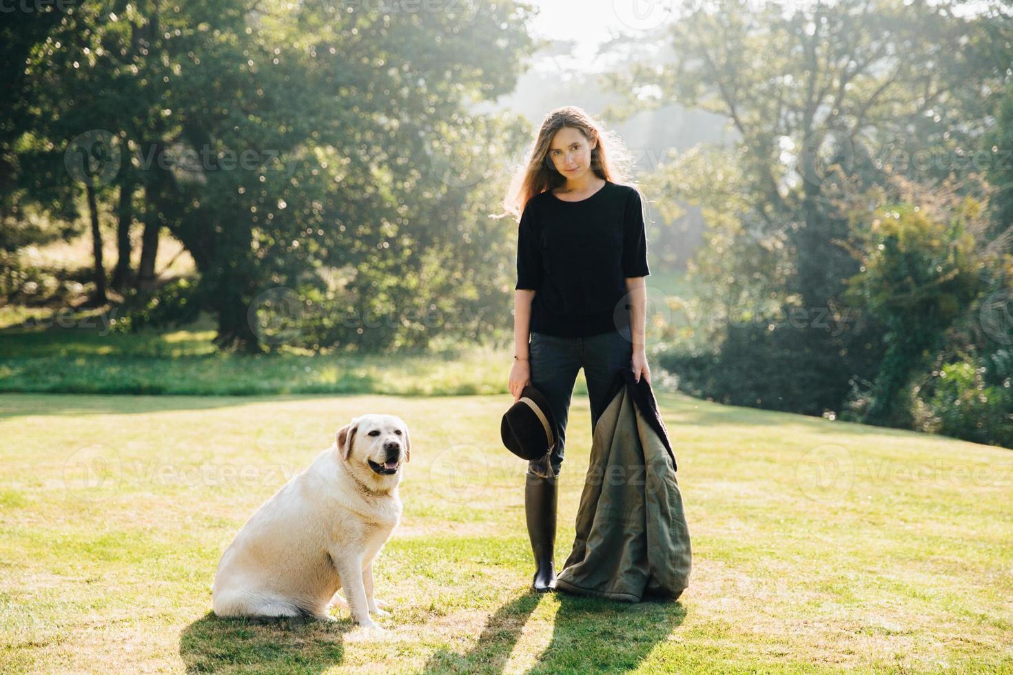 Frau mit Hund auf sonnigem Rasen foto