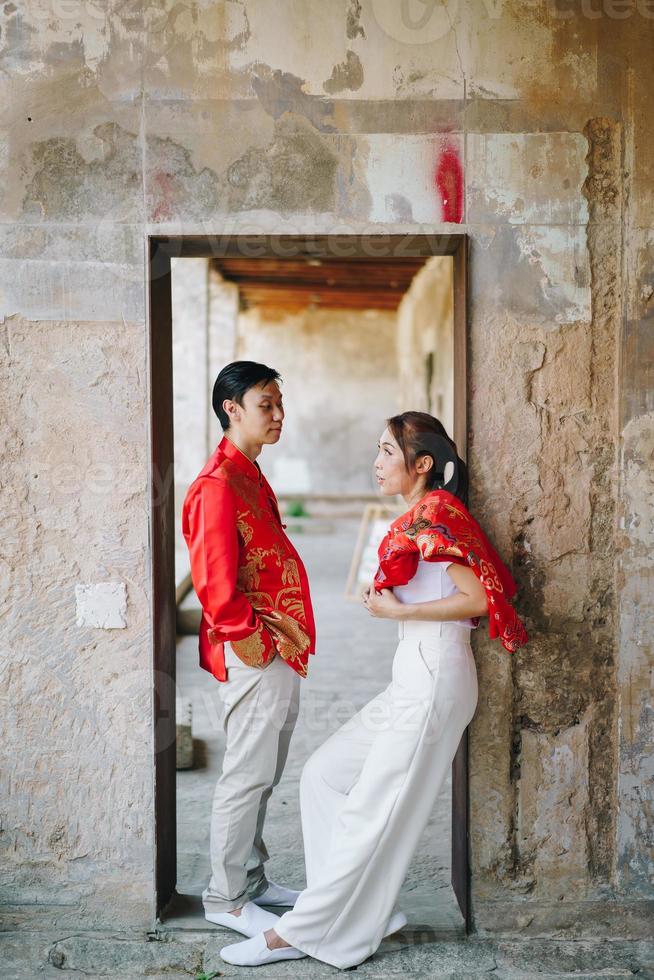 glückliches junges asiatisches paar in chinesischen traditionellen kleidern foto