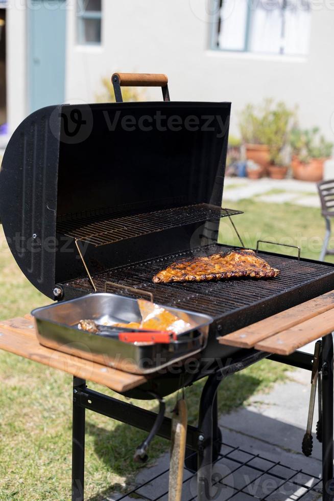 Vertikale Aufnahme von Fleisch, das draußen auf einem Grill gegrillt wird foto