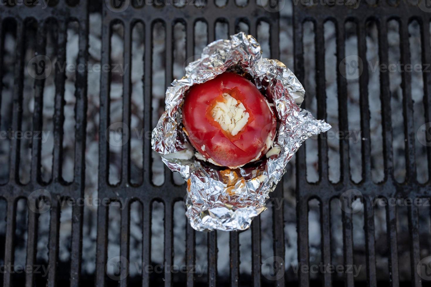 Draufsicht Schuss einer roten Paprika gefüllt mit Käse auf einem Grill im Freien foto