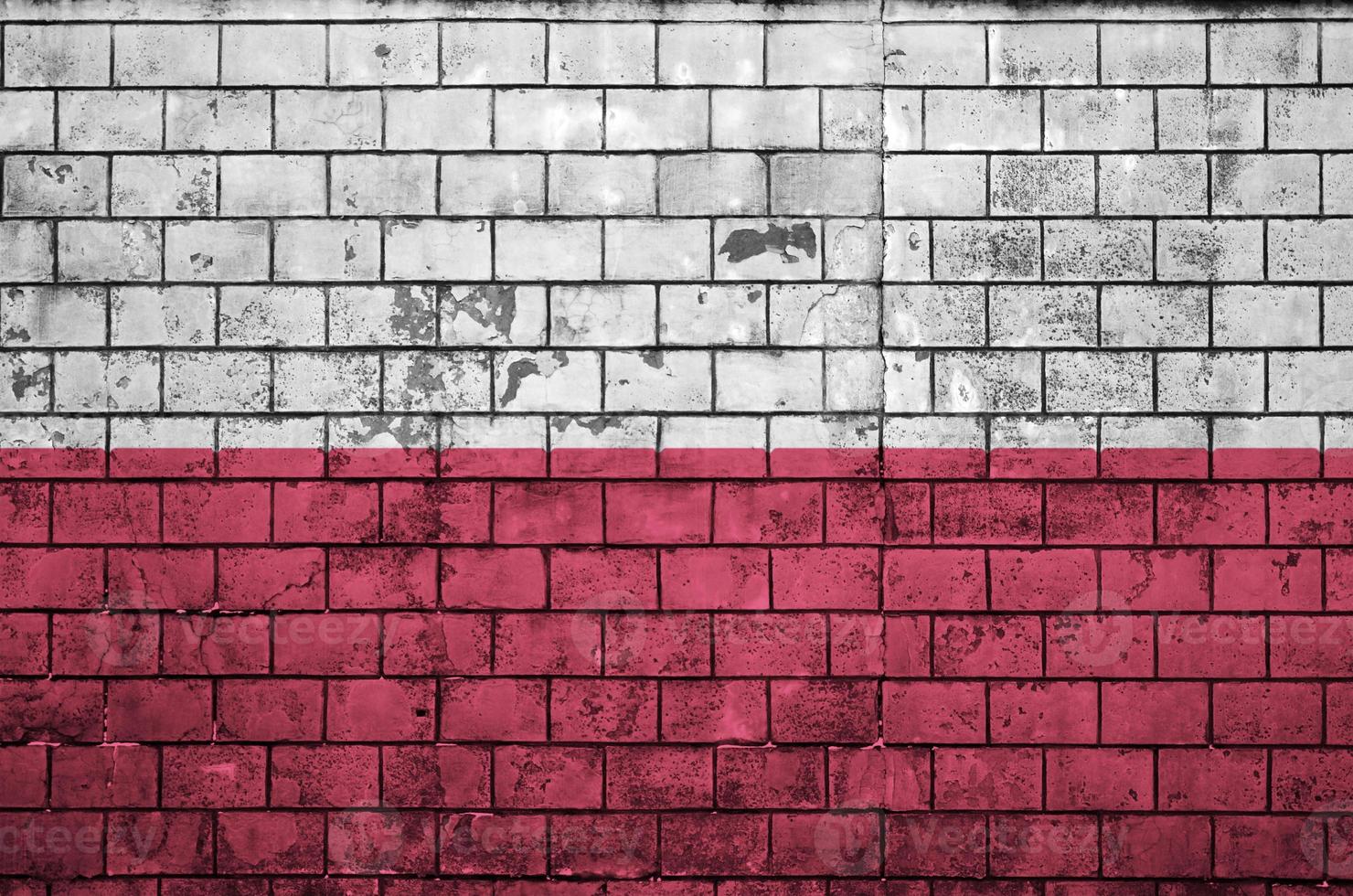 Die polnische Flagge ist auf eine alte Mauer gemalt foto