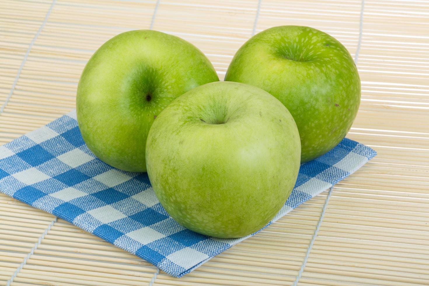 grüner Apfel auf Holz foto