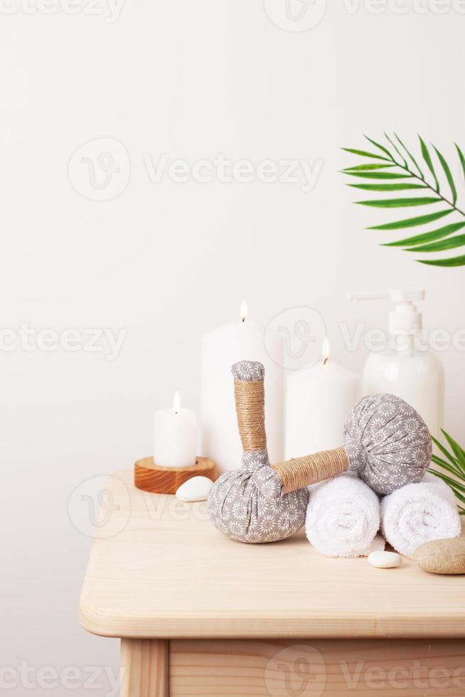 Spa-Behandlung mit Kräuterbeuteln und Kerze auf weißem Hintergrund. nahaufnahme, kopierraum foto