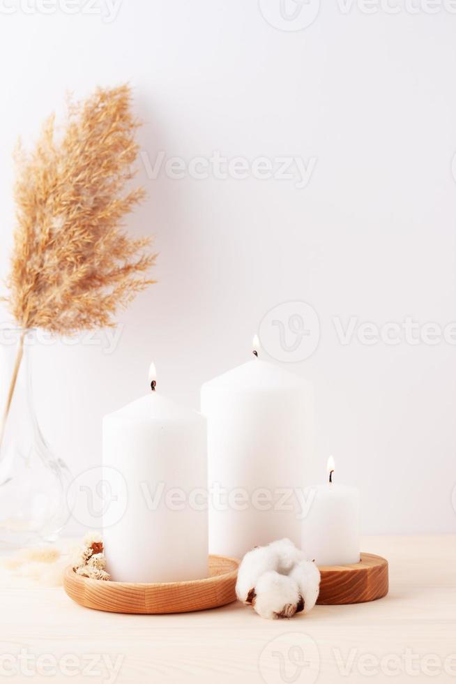 heimtextilien mit kerzen und blumen über weißer wand. Innenarchitekturkonzept. nahaufnahme, kopierraum foto