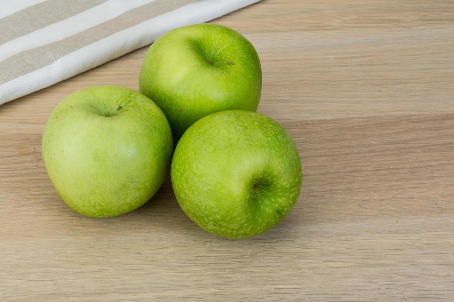 grüner Apfel auf Holz foto