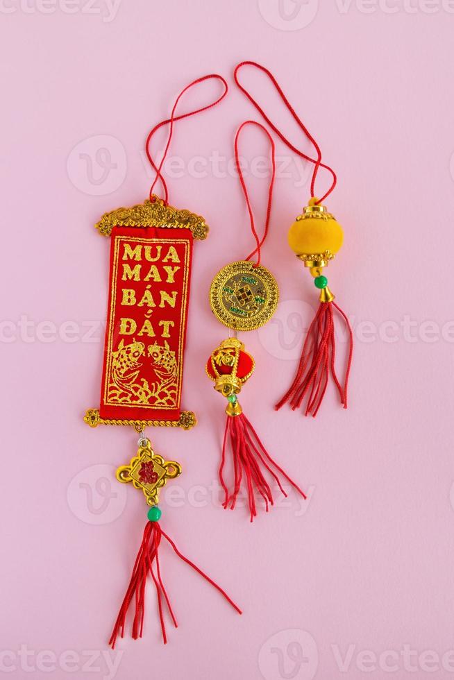 traditionelle chinesische und vietnamesische neujahrsdekorationen rote und goldene farben auf einem rosa hintergrund, draufsicht. foto