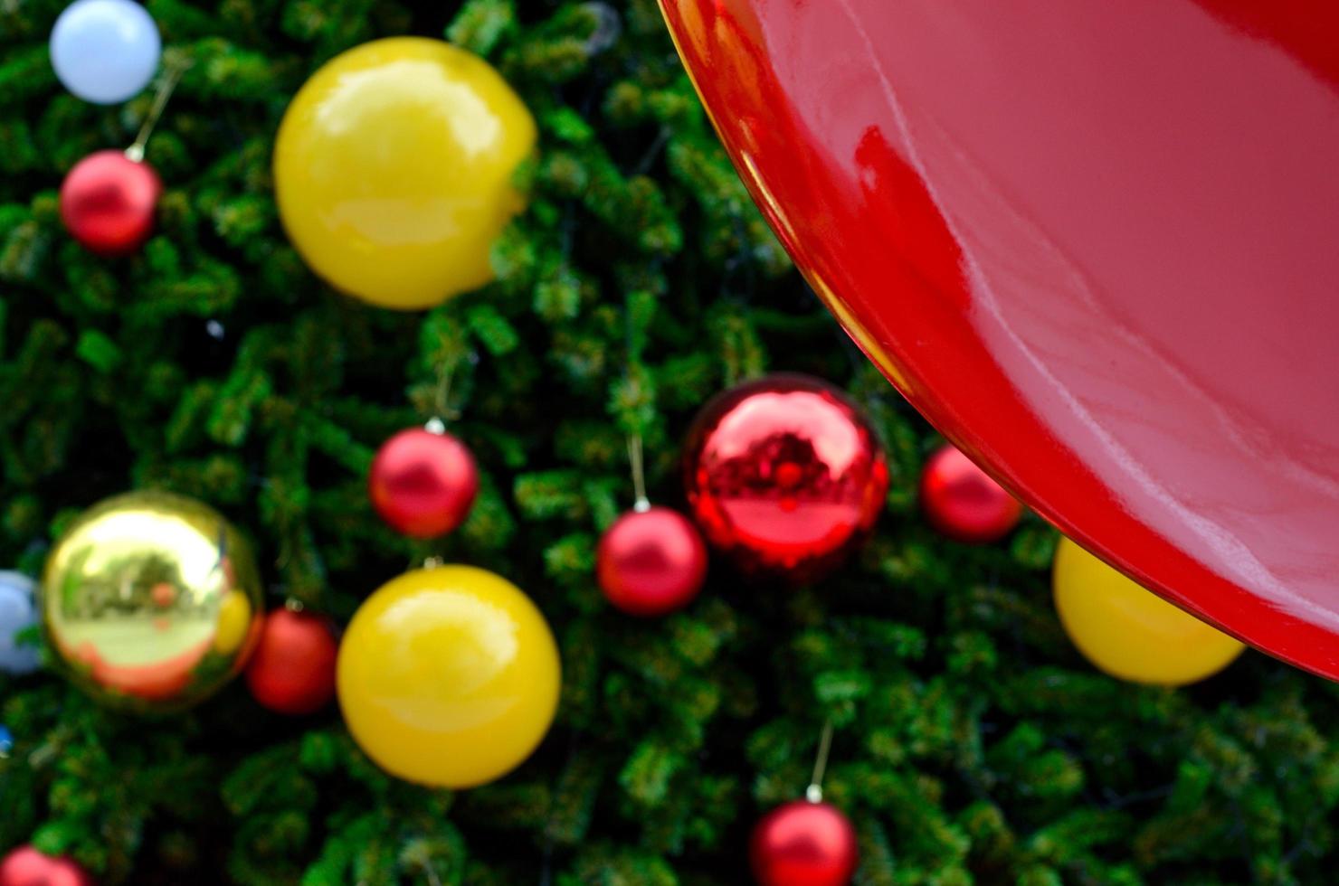weihnachtsbaum schmückt mit roten, goldenen und lächelnden gelben kugeln für weihnachtsferien im dezember foto