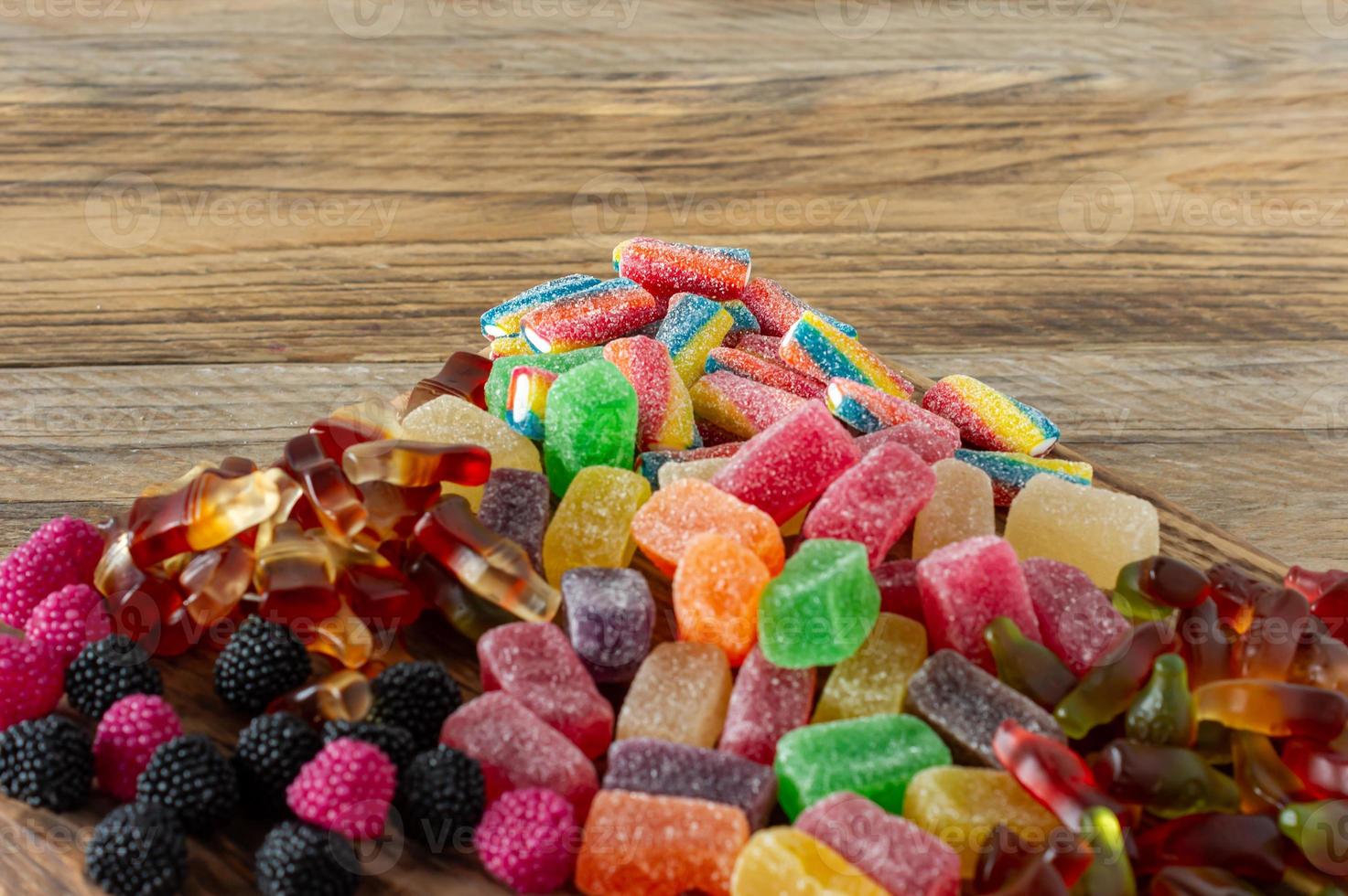 Fruchtmarmeladenbonbons, Geleebonbons auf einem Holzschreibtisch. Obst natürliches Dessert mit Zucker foto