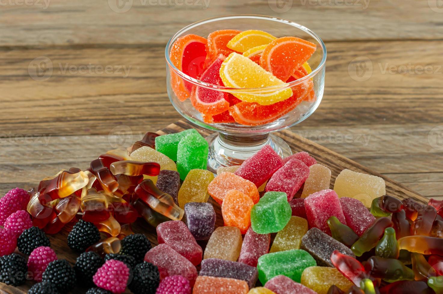 Fruchtmarmeladenbonbons, Geleebonbons auf einem Holzschreibtisch. Obst natürliches Dessert mit Zucker foto