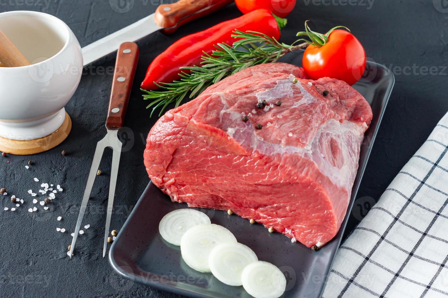 frisches und rohes Rindfleisch. Ganzes Stück Filet für Steaks und Gewürze bereit zum Kochen auf dunklem Hintergrund foto